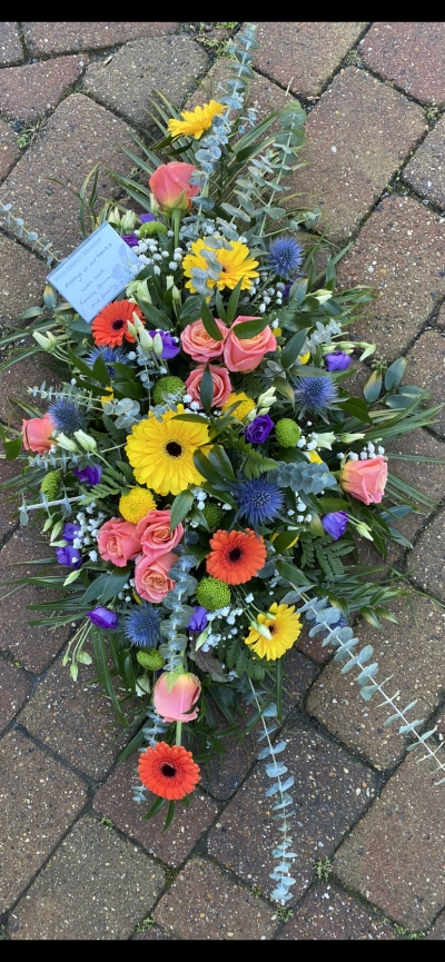 Bright coloured casket spray 